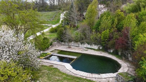 an aerial view of a pool of water in a garden at Maison Terre Les Cabanes de Fallot - sauna bain-froid piscine naturelle in LʼIsle-Bouzon