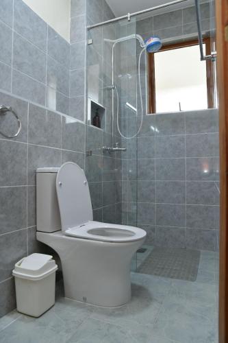 a bathroom with a toilet and a glass shower at Nivaro Homes in Nakuru