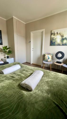a bedroom with a large green bed and a chair at Villa Utsikten Romsdalshorn in Åndalsnes