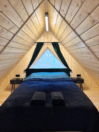 a large bed in a room with a large window at Dukaty House 2 in Verkhovyna