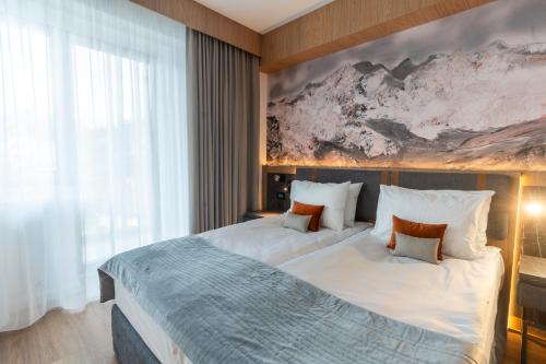 a bedroom with a large bed with a painting on the wall at Azuga Ski & Bike Resort in Azuga