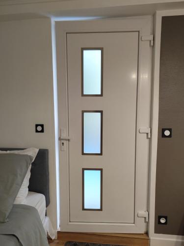 a door with four windows in a bedroom at Charmant Studio indépendant in Louvres