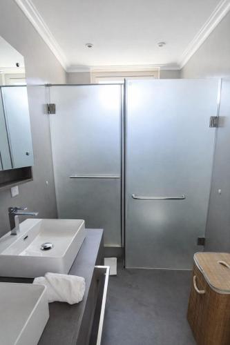 a bathroom with a shower and a white sink at RayGrass, La Gaulette in La Gaulette