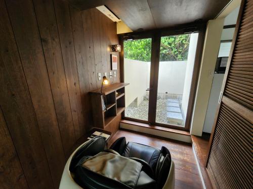 a living room with a chair and a window at Private Villas Ryuz備瀬 in Motobu