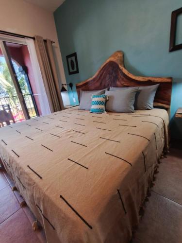 a large bed with a wooden headboard in a bedroom at Casa Punta Perula VILLAS in Pérula