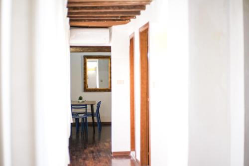 a hallway with columns and a table with a mirror at Drago D'oro Boutique Apartment in Florence