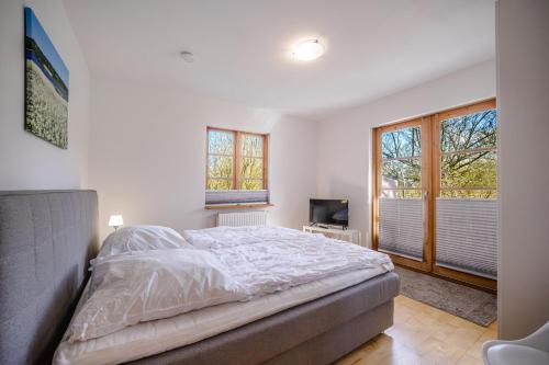 a bedroom with a bed and a tv and windows at Odin in Goltoft