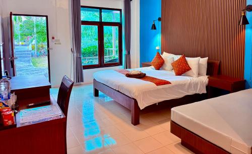 a bedroom with a bed and a table and a desk at Ao Nang Baan Suan Resort in Ao Nang Beach