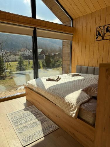 a bedroom with a bed in front of a large window at Nest house in Skole
