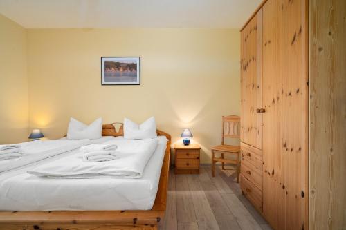 a bedroom with a large bed with white sheets at Ferienwohnung Haus Vietzen 2 in Rechlin