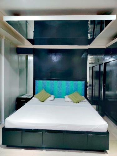 a bedroom with a large white bed with blue walls at Fields Palace Hotel in Angeles