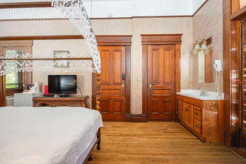 a bedroom with a bed and a sink and a tv at Curry Mansion Inn in Key West
