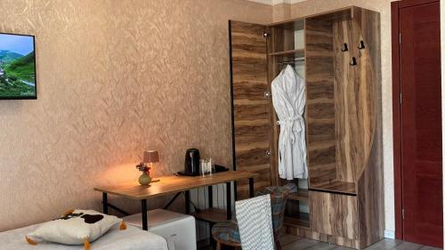 ein Zimmer mit Schreibtisch, Tisch und Kleiderschrank in der Unterkunft Hotel Gold Tower in Mestia