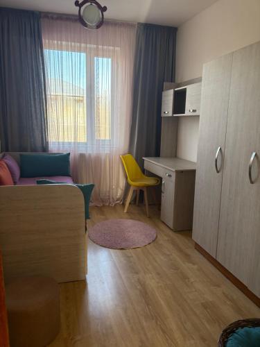 a small room with a desk and a yellow chair at TREFOIL in Lori Berd