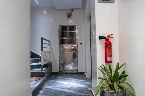 a hallway with a fire extinguisher in front of a door at Résidence Madior C1 in Dakar