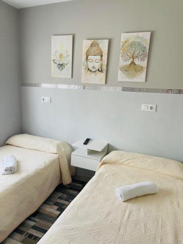 a bedroom with two beds and pictures on the wall at Coalla Rooms Luxe in Lugones