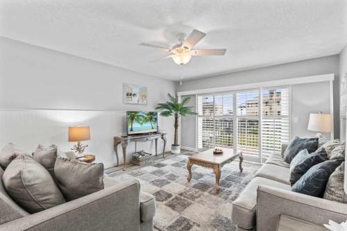 a living room with a couch and a ceiling fan at St Augustine Beachfront Condo with Ocean Views in Saint Augustine Beach