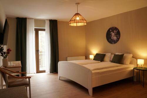 a bedroom with a white bed and a chandelier at Ley Hotel in Klotten