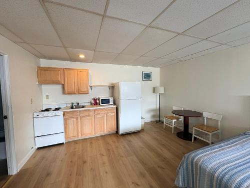 a kitchen with a refrigerator and a table in a room at Seabreeze Motel in Old Orchard Beach