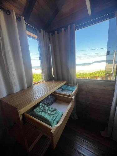 a room with two bunk beds and a window at Chalé Rosa dos Ventos in Itapoa
