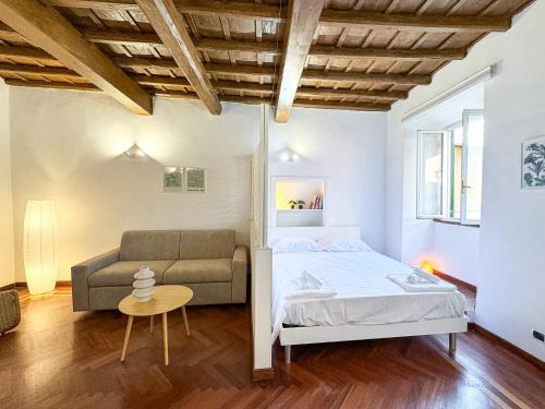 a bedroom with a bed and a couch at Il Vicoletto Marino in Marino