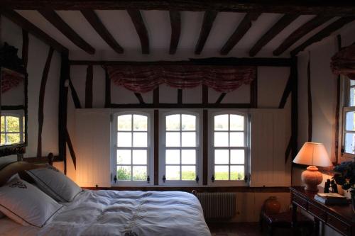 a bedroom with a large bed with four windows at La Bonne Auberge - Seine Panorama SAS in Vieux-Port
