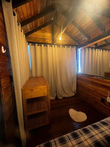 a room with a bed and a white curtain at Chalé Rosa dos Ventos in Itapoa