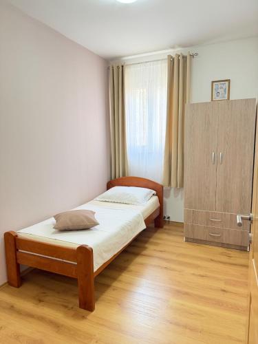 a bedroom with two beds and a cabinet at AS Holiday Home in Ljubuški