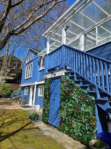 a blue house with a blue staircase and flowers at 7811 The Solace Vista in Vancouver