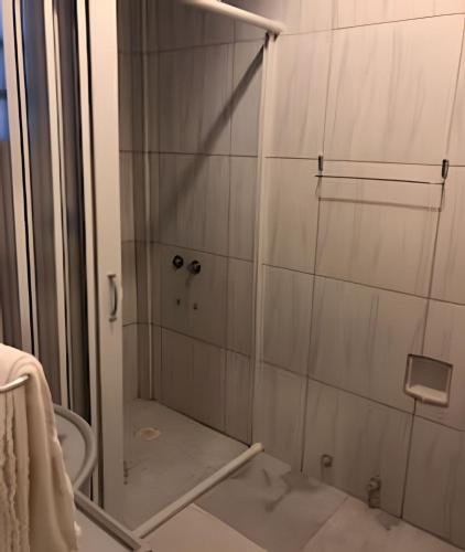 a shower with a glass door in a bathroom at Confortavel Apartamento na Rua das Flores in Curitiba