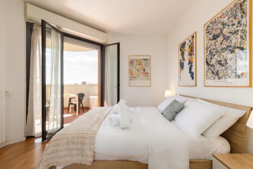 a bedroom with a white bed and a large window at Milano Lux Apartament - Private Indoor Parking in Sesto San Giovanni