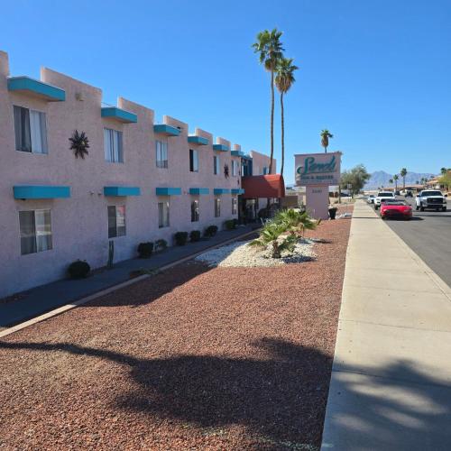 a sidewalk next to a building with a palm tree at Sands Inn & Suites Lake Havasu City in Lake Havasu City