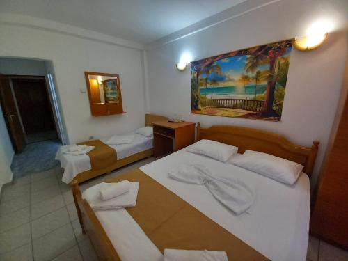 a hotel room with two beds and a table at Casa Paloma in Costinesti