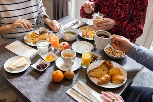 a group of people sitting at a table eating breakfast at Best Western Plus Hotel Villa D'est in Strasbourg