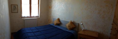 ロッカラーゾにあるAppartamentino Roccarasoのベッドルーム(青いベッド1台、窓付)