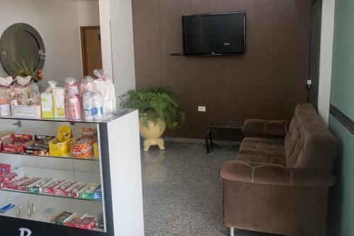 a living room with a couch and a television at Hotel Royal - Rubiataba in Rubiataba