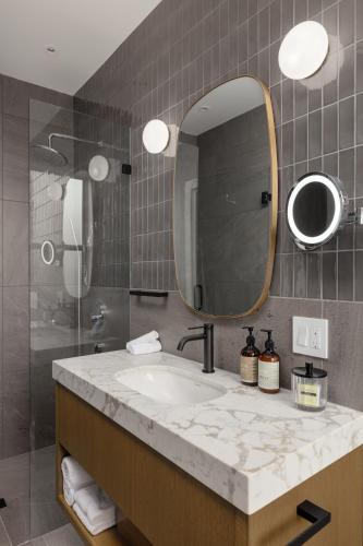 a bathroom with a sink and a mirror at Victorian Hotel in Vancouver