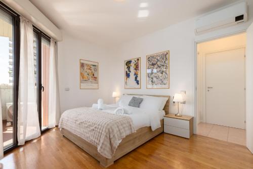 a white bedroom with a bed and two lamps at Milano Lux Apartament - Private Indoor Parking in Sesto San Giovanni