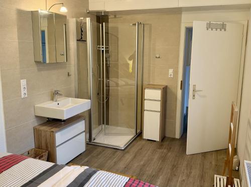 a bathroom with a sink and a shower and a bed at Ferienwohnung Moselblick in Ediger-Eller
