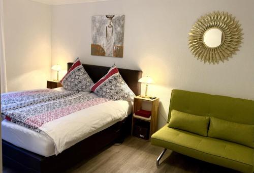 a bedroom with a bed and a green chair at Ferienwohnung Moselblick in Ediger-Eller