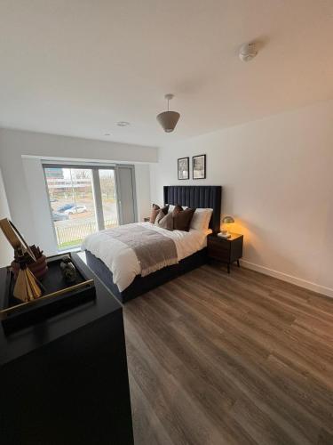 a bedroom with a bed and a large window at Stylish 2 bedroom modern apartment central to Eccles in Manchester