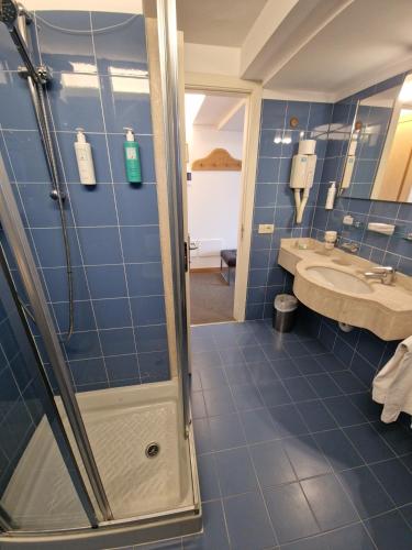 un bagno blu con doccia e lavandino di City Hotel a Senigallia