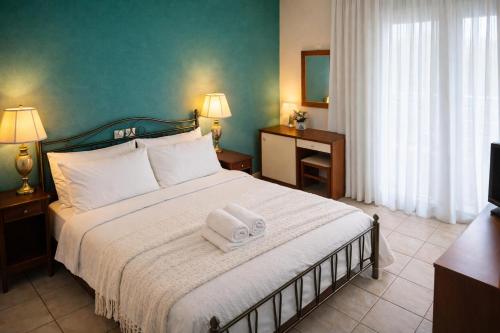a bedroom with a large bed with two towels on it at Πανθεον in Kamena Vourla