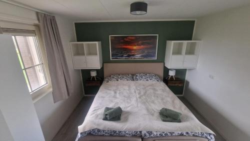 a bedroom with a bed and a green wall at 't Olde Land in Den Burg