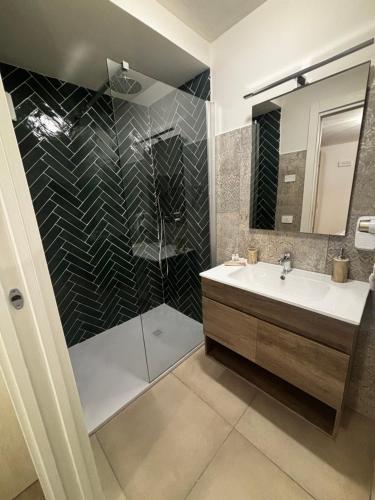 a bathroom with a glass shower and a sink at I due archi in Norcia