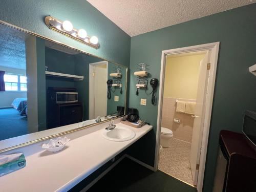 a bathroom with a sink and a large mirror at Cherokee Inn in Cherokee