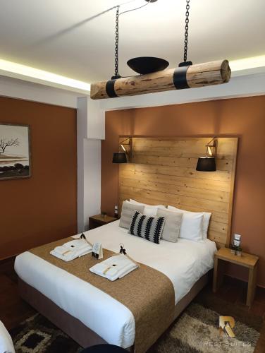 a bedroom with a large bed with a wooden headboard at REST On The Pedestrian Street in Kalavrita