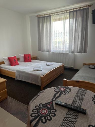 a bedroom with two beds and a window at Karczma Mikuda - Sauna Basen Jacuzzi z widokiem na góry - Kuligi - Parking in Zakopane