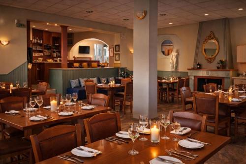 a restaurant with wooden tables and chairs and a fireplace at Πανθεον in Kamena Vourla