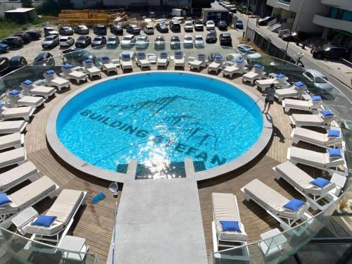 an overhead view of a swimming pool with chaise lounge chairs at Building Stefan Resort 2 Mamaia Nord - Studio 804 in Năvodari
